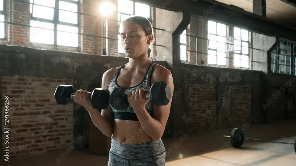 Fit woman doing arm exercise with weight on workout at gym Fit woman doing arm exercise with weight on workout at gym