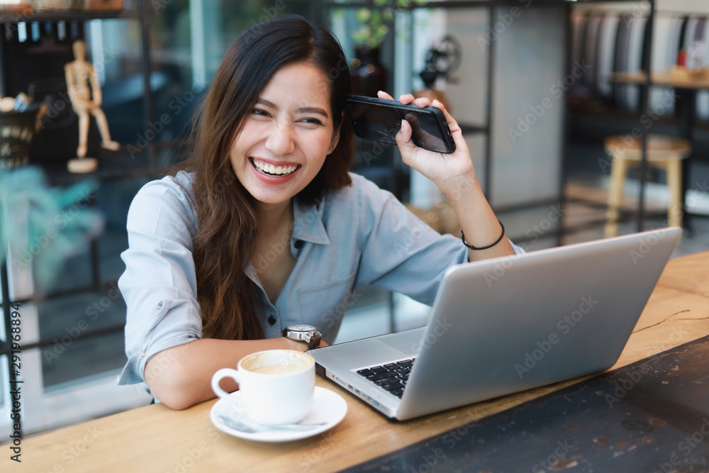 Asian woman in blue shirt working and drink coffee in coffee shop cafe vintage color tone Asian woman in blue shirt working and drink coffee in coffee shop cafe vintage color tone