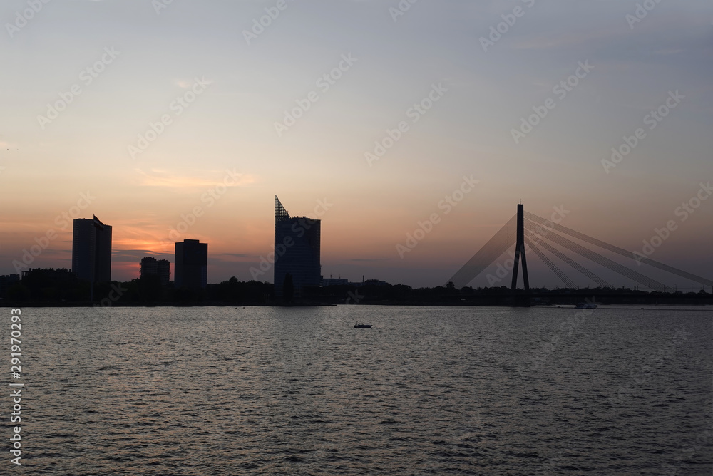 Obraz premium Beautiful view of cable-stayed bridge across the Daugava river in Riga forward on sunset front view