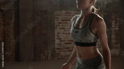 Fit woman doing jumping jack exercise at fitness gym