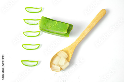 Aloe vera fresh leaves with slices and gel on wooden spoon on white background.