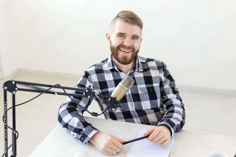 Podcasting, music and radio concept - young dj at radio studio Podcasting, music and radio concept - young dj at radio studio