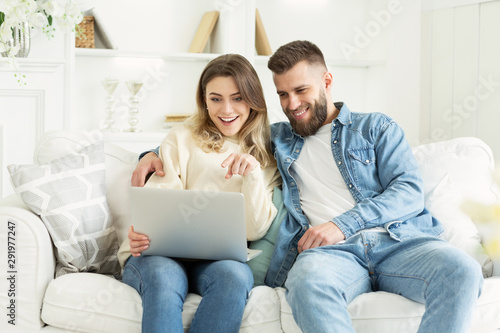 Happy couple using laptop and choosing film for watch