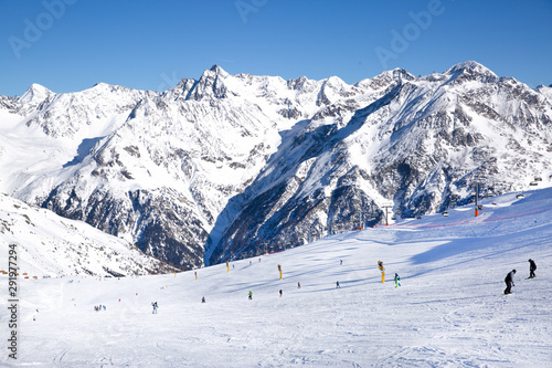 Skiers skiing downhill, Tirol (Tyrol) Austria. Big Alps panorama. Winter day. © Nataliia