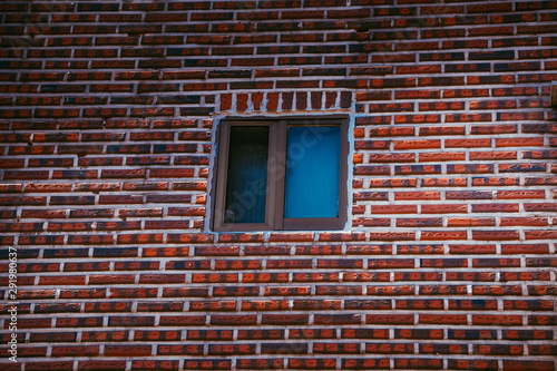 Winow in the middle of the red brick wall.