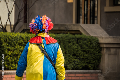 Sad clown is walking on the street. He is alone and nobody cares about his feelings.