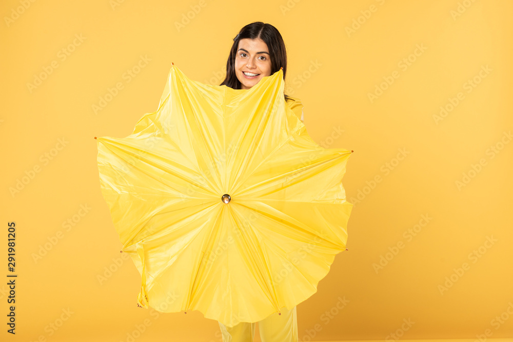 smiling girl posing with umbrella, isolated on yellow smiling girl posing with umbrella, isolated on yellow
