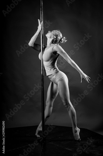 Samolepka Beautiful athletic busty elegant blonde girl performs artistic elements of an exotic dance on a gray background