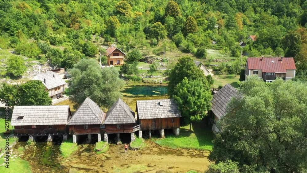 Croatia, countryside in region of Lika, Majerovo vrilo river source of Gacka, drone flying over traditional old wooden mills and cottages Croatia, countryside in region of Lika, Majerovo vrilo river source of Gacka, drone flying over traditional old wooden mills and cottages