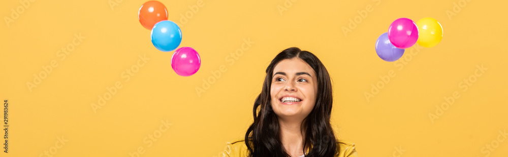 happy attractive girl with colorful balls, isolated on yellow happy attractive girl with colorful balls, isolated on yellow