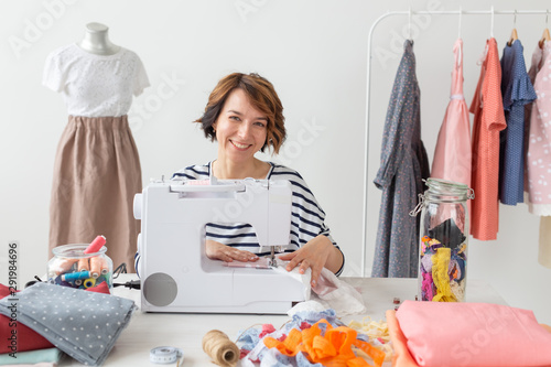 Concept of designer clothes. Woman seamstress working in studio photo