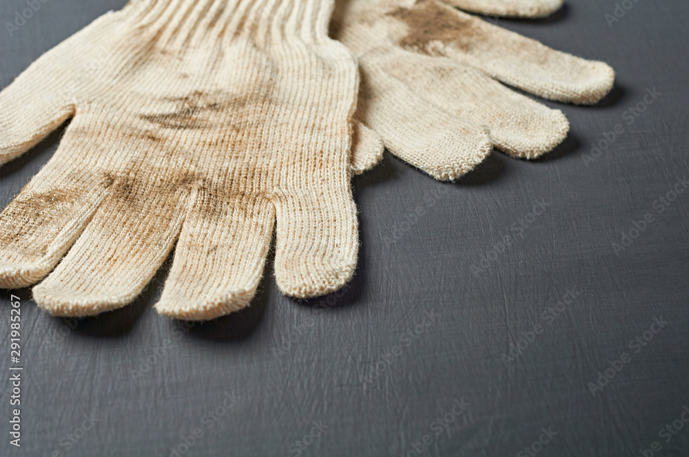 Pair of dirty protective white textile gloves after hard work lies on dark  scratched concrete table in workshop. Space for text Stock-Foto | Adobe  Stock