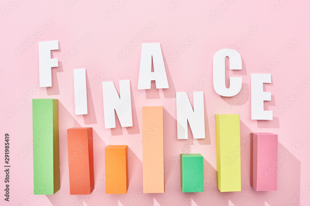 top view of finance inscription with color graph on pink background