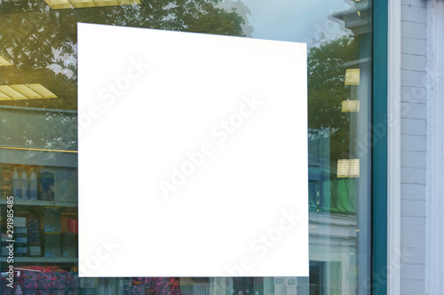 advertising blank white sign on glass of window showcase shop outside on city street, mock-up