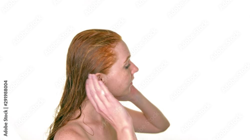 Profile side view of young redhead woman rubbing conditioner in wet hair slow motion in studio Profile side view of young redhead woman rubbing conditioner in wet hair slow motion in studio