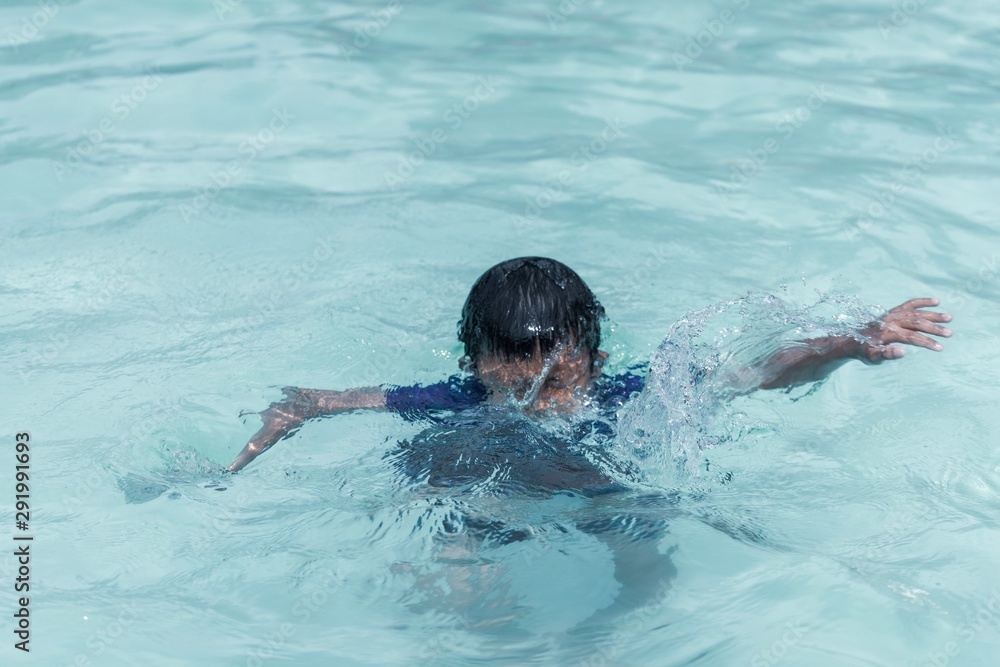 Small children age 7-10 drowned in clear water swimming pool with two hand up to the air asking for help.