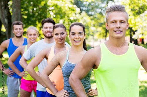 fitness, sport and healthy lifestyle concept - group of happy friends or sportsmen at summer park