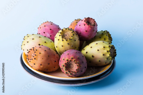 Whole fresh prickly pear fruit in a plate on a pastel blue background backdrop. Prickly pear or Fichi Dindia Salento, Puglia. Minimalism photo