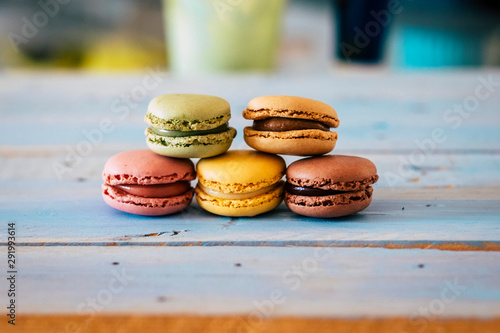 Close up of tasty bakery macarones on a blue woden rustic table - sweet cakes made from bakery chef with cream and chocolate flavours photo