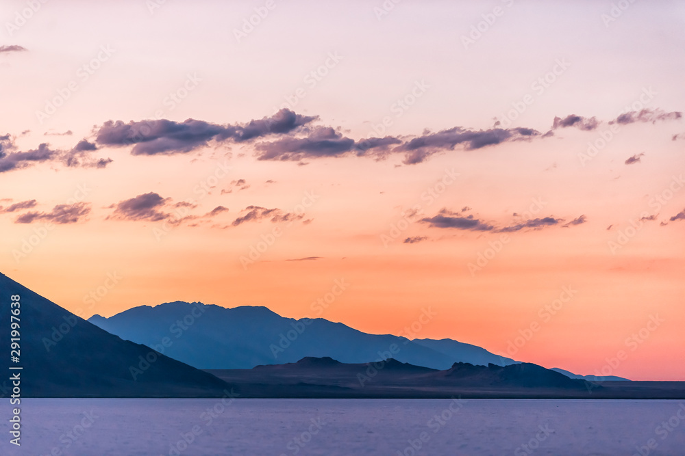 Bonneville Salt Flats colorful purple red twilight silhouette mountain view after sunset near Salt Lake City, Utah with clouds