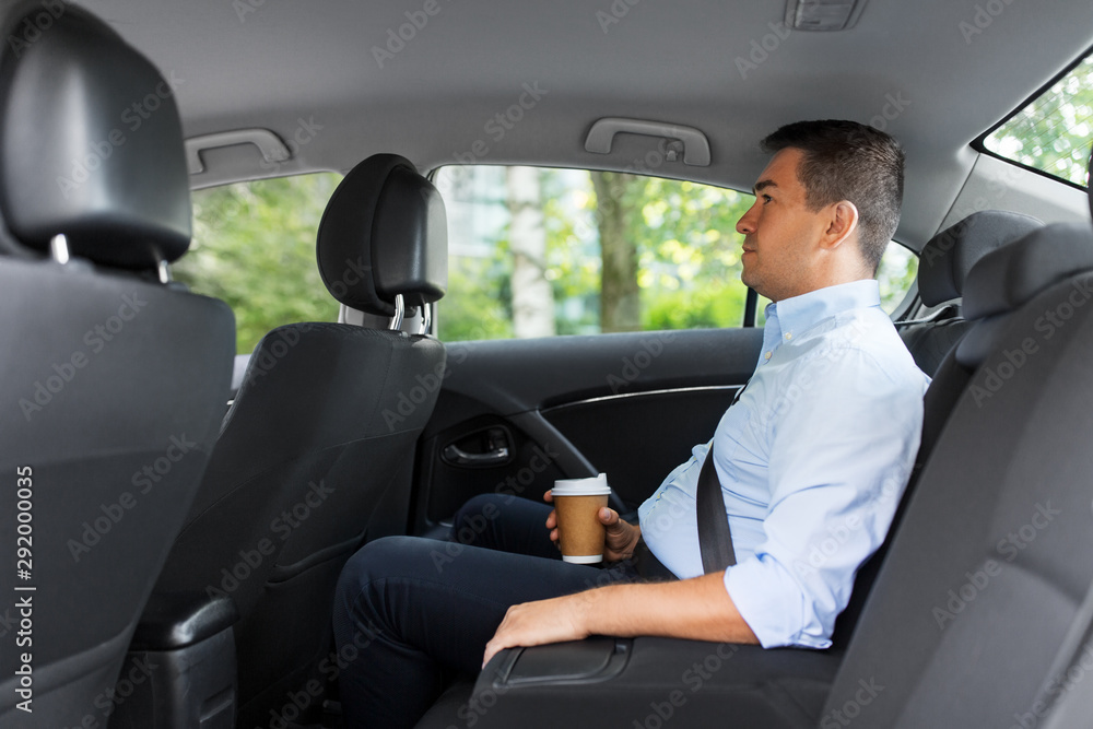 © Syda Productions - transport, business and people concept - businessman drinking takeaway coffee on back seat of taxi car