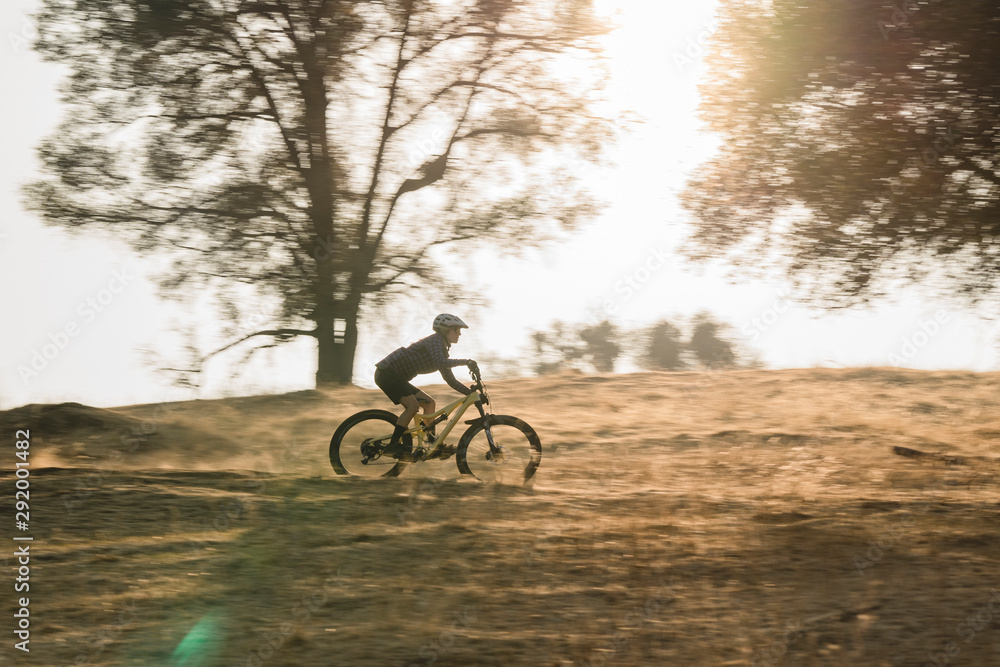 female mountain bike rider riding in fall during sunset