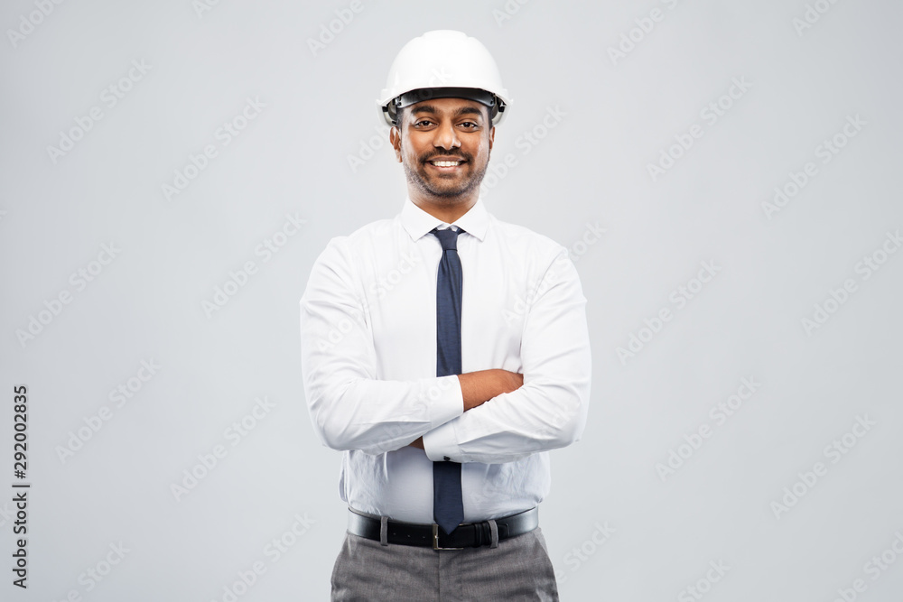 architecture, construction business and people concept - smiling indian male architect in helmet over grey background architecture, construction business and people concept - smiling indian male architect in helmet over grey background