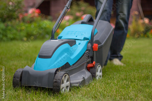 farmer mows grass with a lawn mower. Garden care