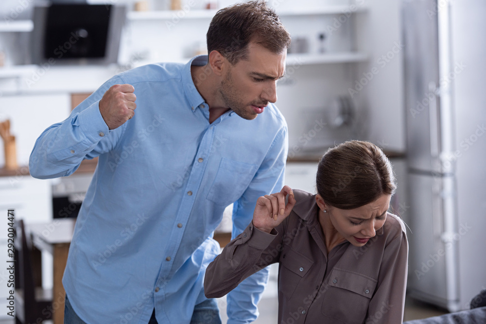 aggressive man in shirt beating scared wife during quarrel aggressive man in shirt beating scared wife during quarrel