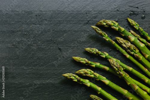 Close up of fresh picked asparagus tips on black slate countertop photo