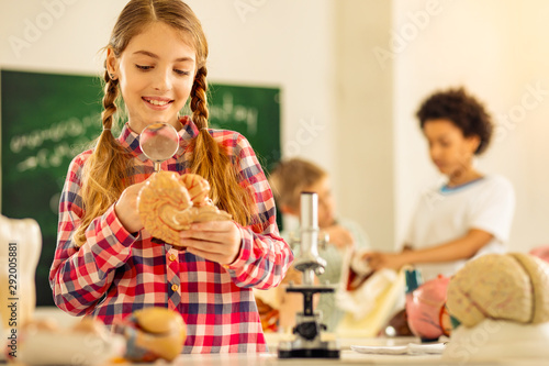 Positive delighted girl examining model of brains