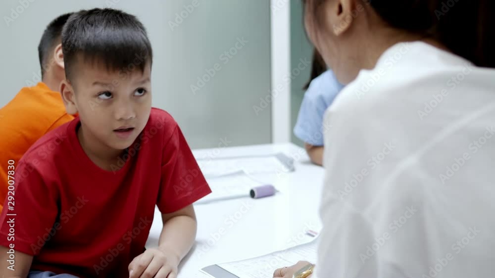 The Asian elementary school children are studying in the classroom with an Asian female teacher. The Asian elementary school children are studying in the classroom with an Asian female teacher.