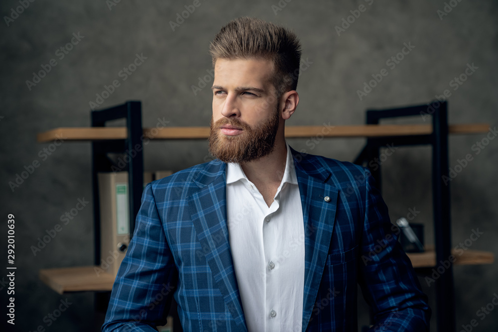 Portrait of smart responsible man with modern hairdo looking away over blurred office hurry up for meeting. Management employment job concept Portrait of smart responsible man with modern hairdo looking away over blurred office hurry up for meeting. Management employment job concept