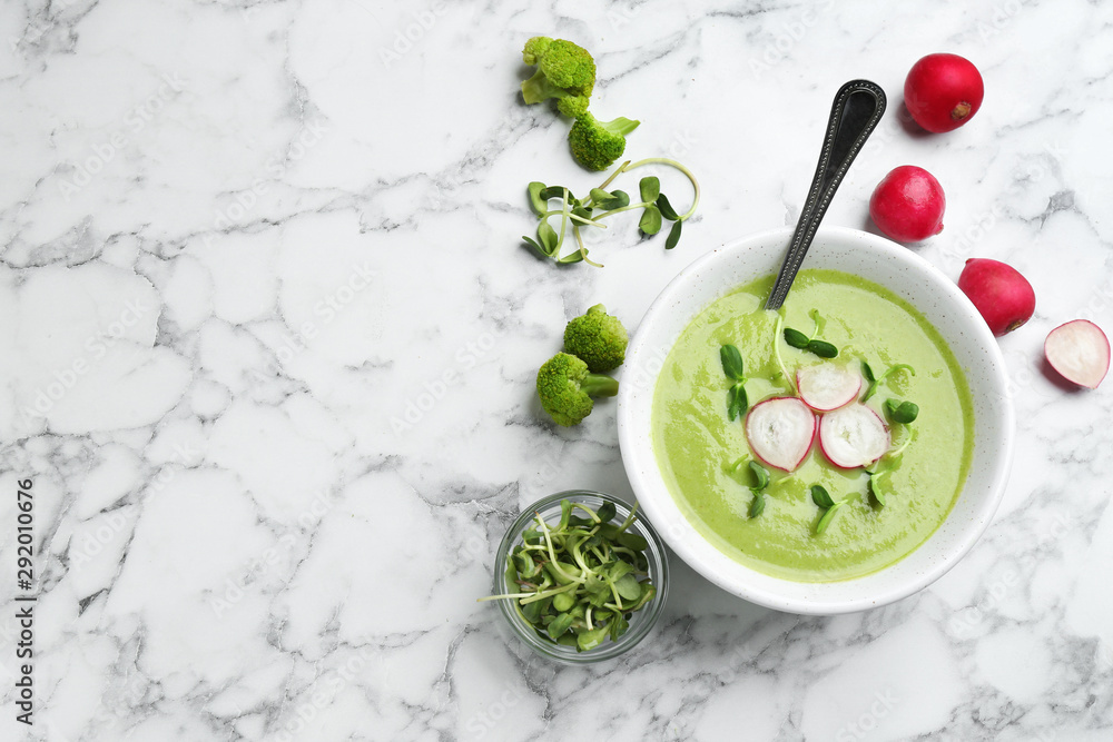 Flat lay composition with bowl of broccoli cream soup on white marble table, space for text Flat lay composition with bowl of broccoli cream soup on white marble table, space for text