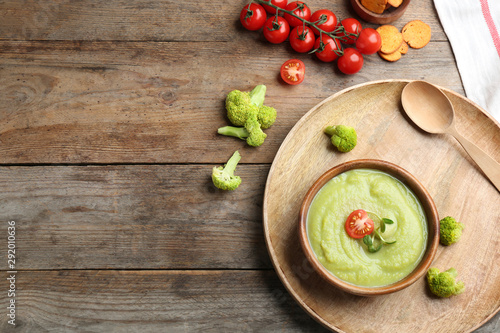 Fototapeta Naklejka Na Ścianę i Meble -  Flat lay composition with bowl of broccoli cream soup on wooden table, space for text