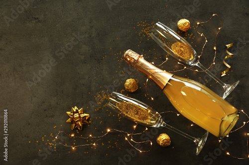 Flat lay composition with bottle of champagne for celebration on grey stone background. Space for text