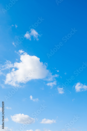 Blue sky background with cumulus clouds.