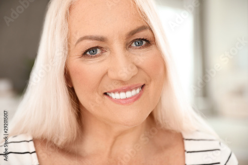 Portrait of mature woman with beautiful face on blurred background, closeup view