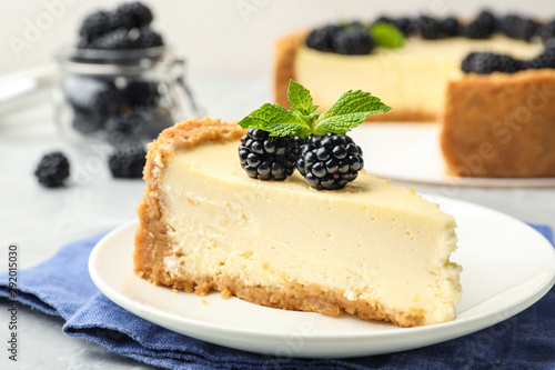 Canvastavla Piece of delicious cheesecake with blackberries on table, closeup