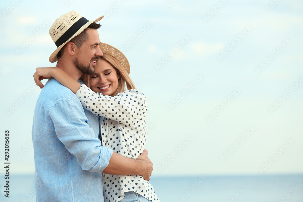 Happy romantic couple spending time together on beach, space for text