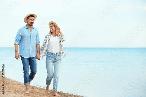 Happy romantic couple walking on beach, space for text © New Africa