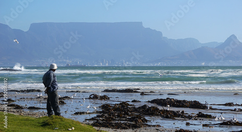 Alone at bloubergstrand in cape town south africa with table mountain and lions head photo