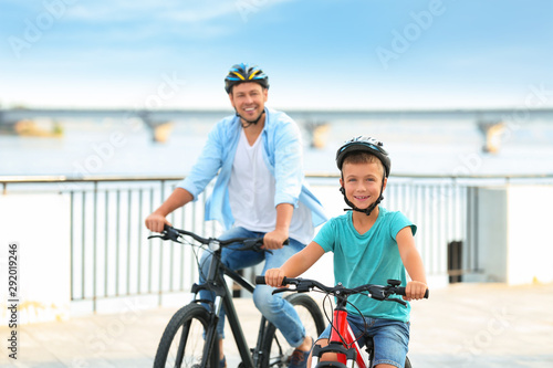 Dad and son riding bicycles together outdoors
