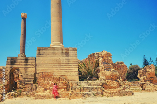 Woman on the background of ancient Roman columns, the ruins of Anthony terms. Archaeological excavations of antique Thermae in Carthage. Tunisia 18 06 2019