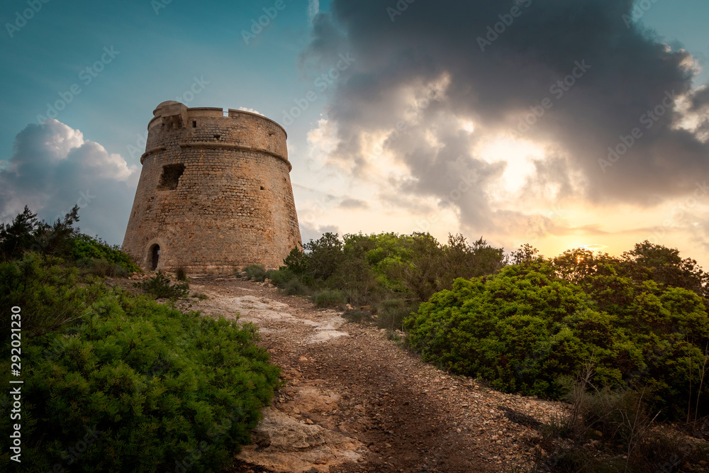 Ibiza, sunrise behind old stone tower, totte de Sal Rossa Ibiza, sunrise behind old stone tower, totte de Sal Rossa