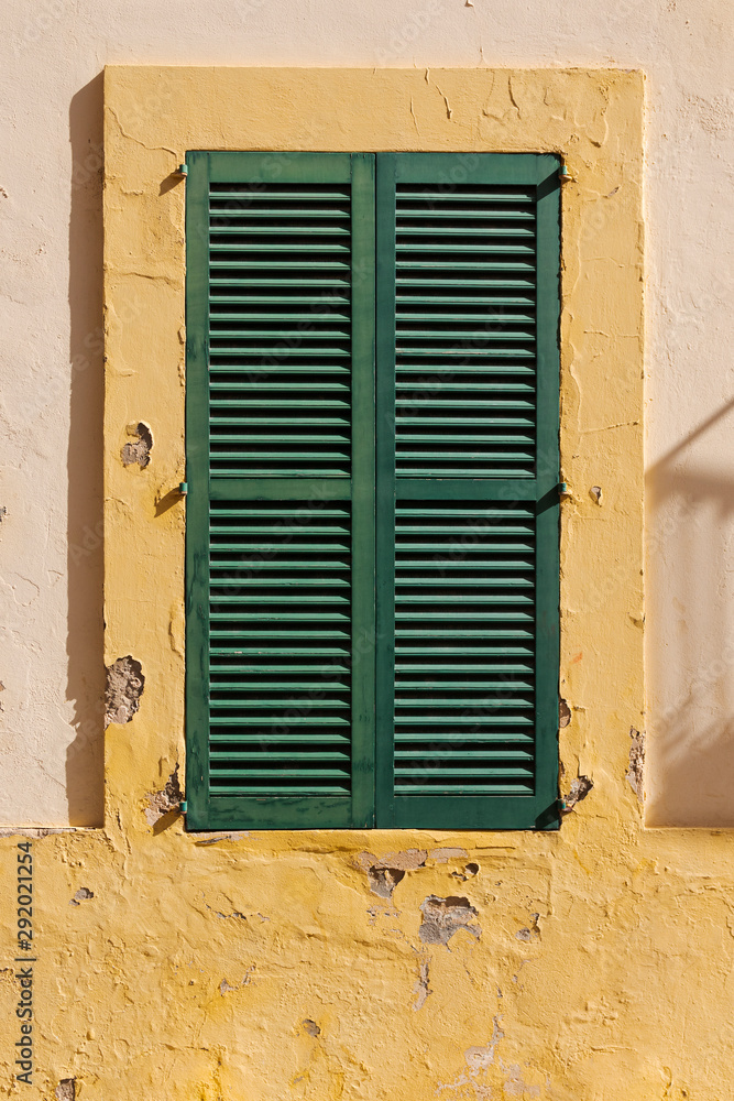 closed green window shutters in an old Mediterranean house