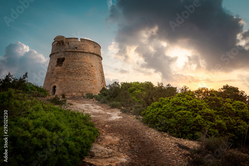 Ibiza, sunrise behind old stone tower, totte de Sal Rossa photo