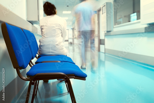Female doctor sitting on the chair in the hospital corridor. photo