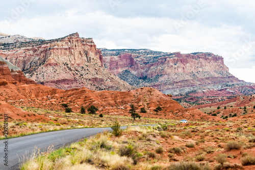 Car on road highway in Capitol Reef National Monument with paved street and colorful stone and cliffs