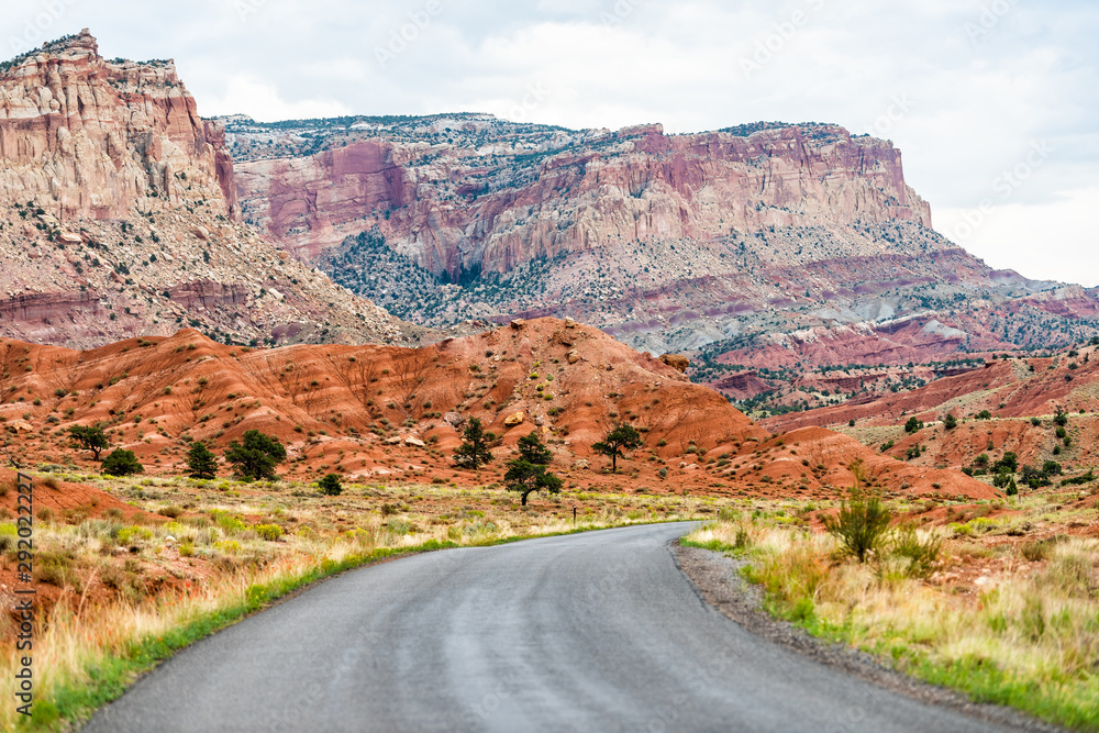 Empty road highway in Capitol Reef National Monument with paved winding street and colorful red stone cliffs Empty road highway in Capitol Reef National Monument with paved winding street and colorful red stone cliffs